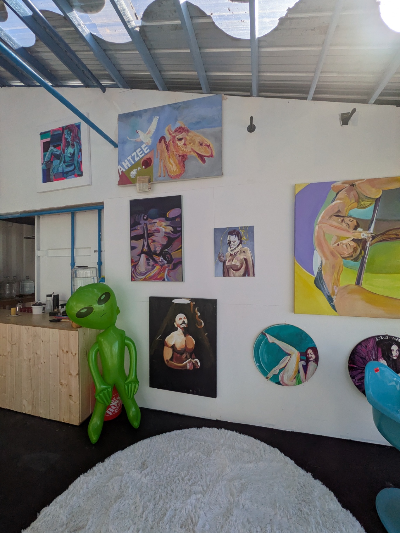 The Figure Wall — Paintings by Evan Moore beside the coffee counter
